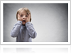 Child with scared expression and hands on each side of his face